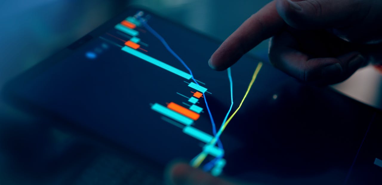 home-hero-bg Close-up of a finger interacting with a digital chart on a tablet, depicting financial data and analysis.